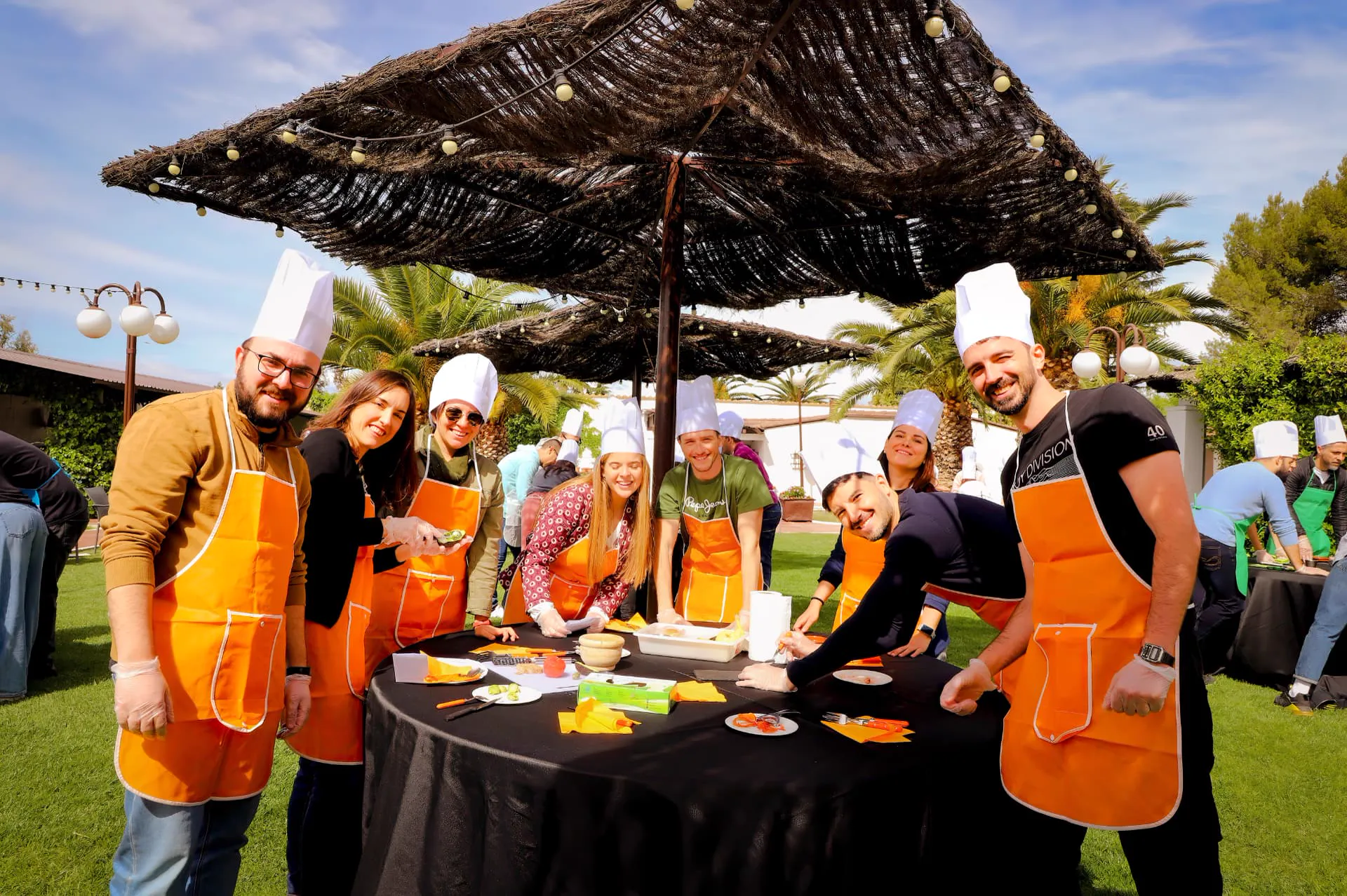 Equipo de empresa realizando una actividad de team building de cocina al aire libre