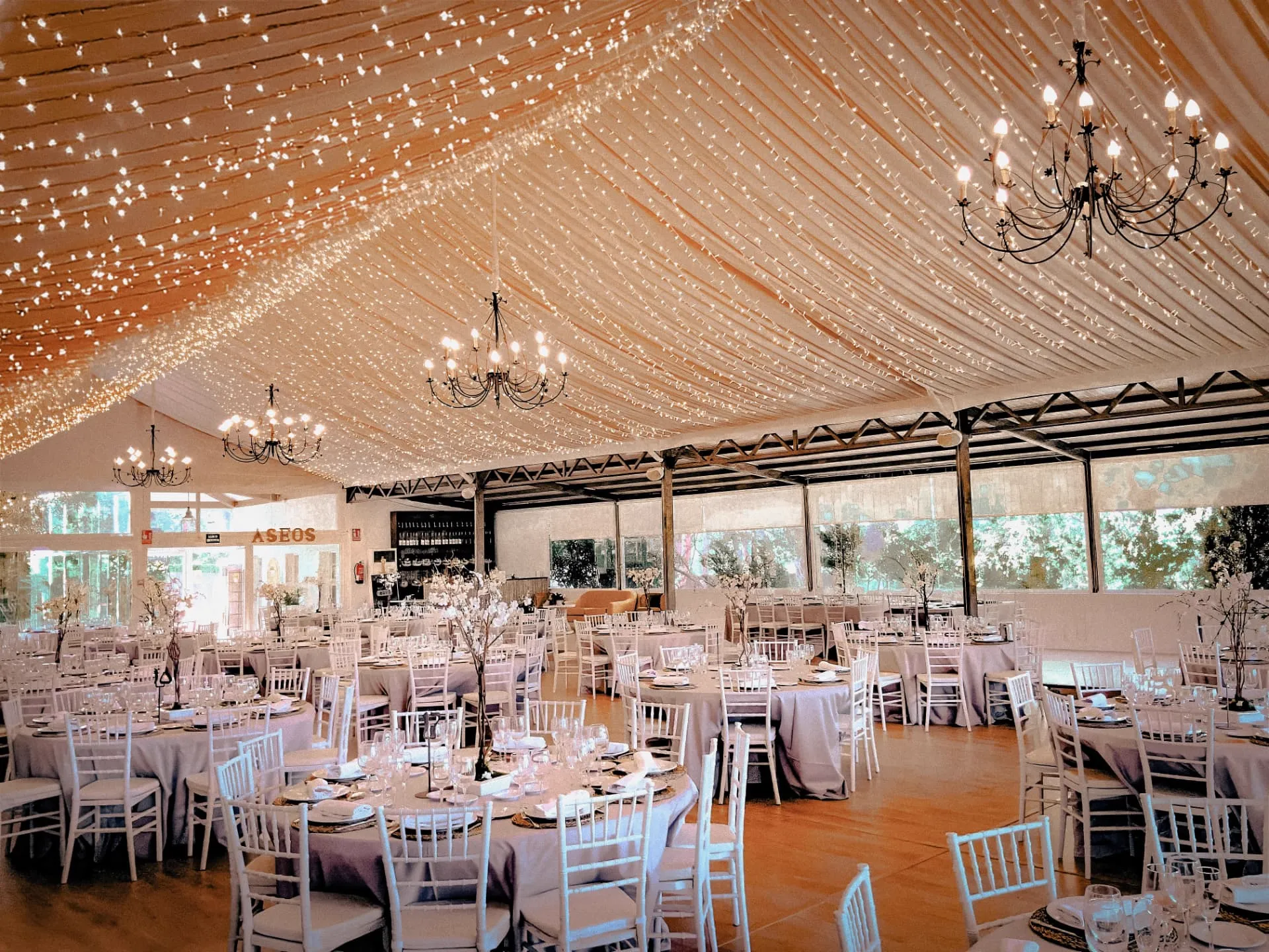 Salón interior con mesas redondas montadas para un evento corporativo