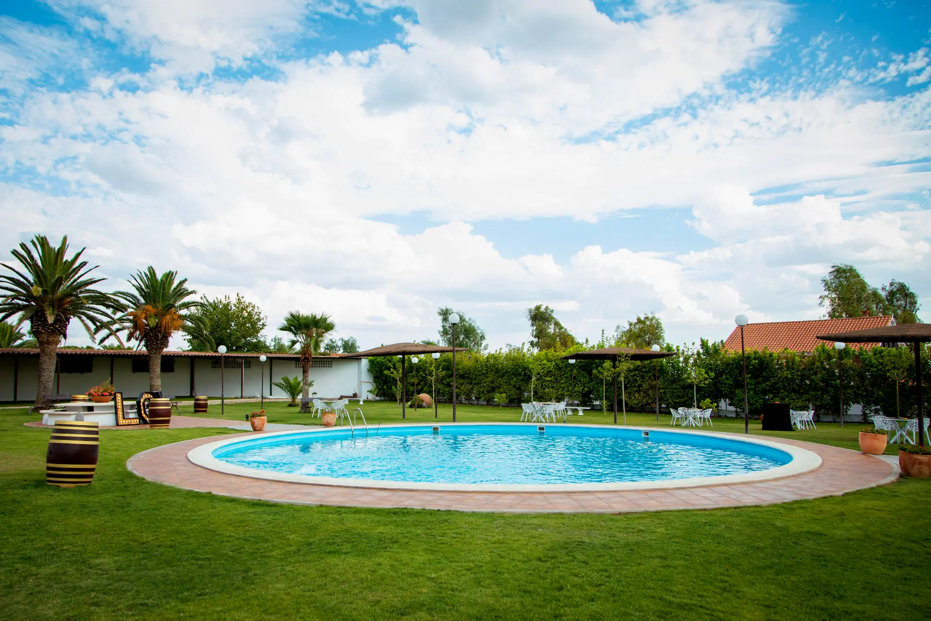 Finca La Plata: piscina circular, césped y jardines bajo un cielo despejado