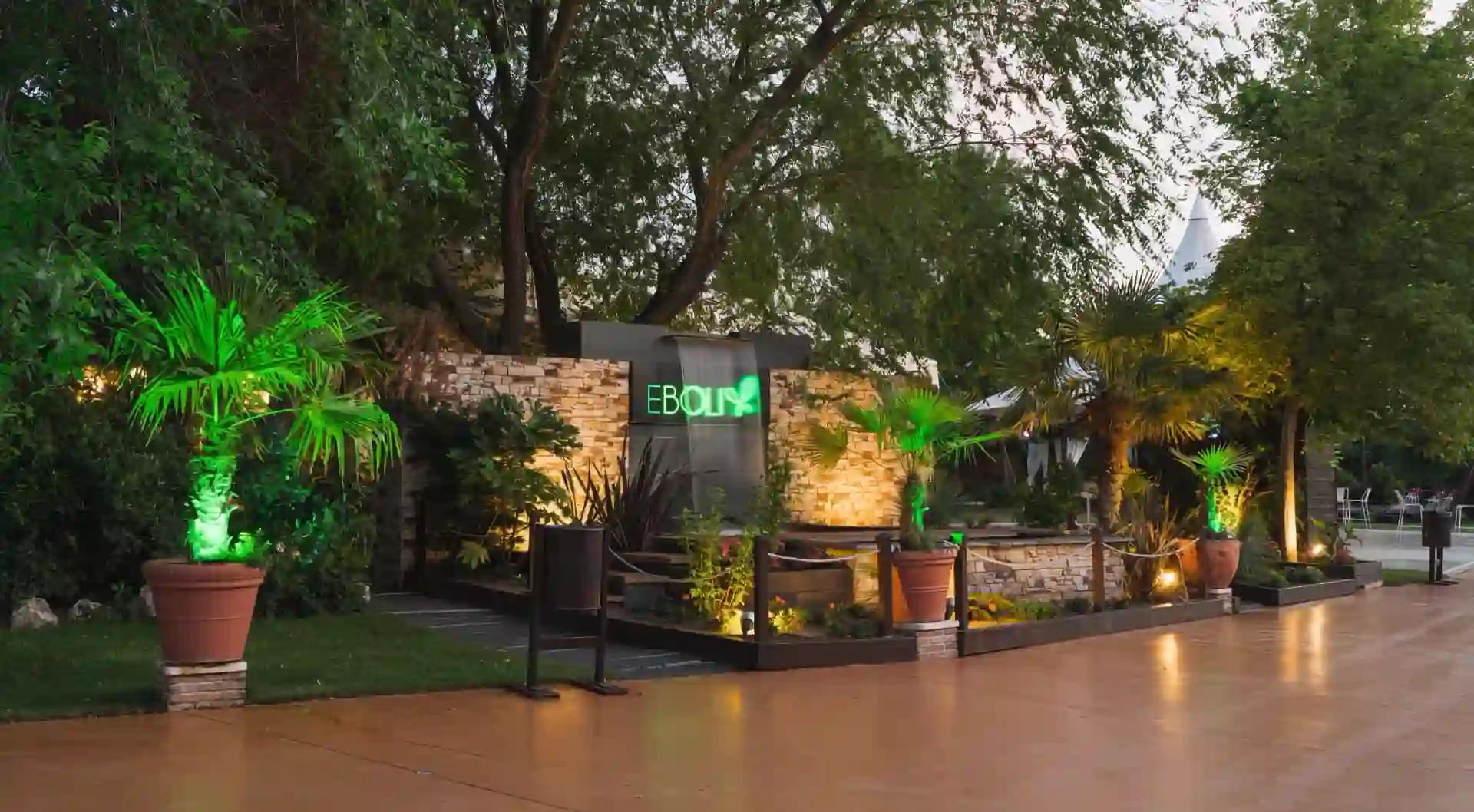 Rincón exterior iluminado de Espacio Éboli con el letrero luminoso de la marca