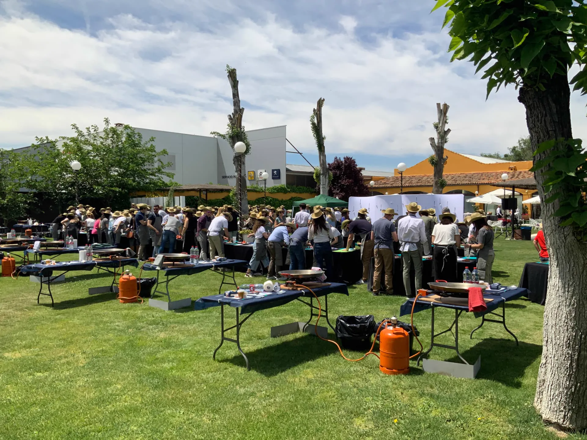 Actividad de team building de cocina al aire libre con paellas en un jardín