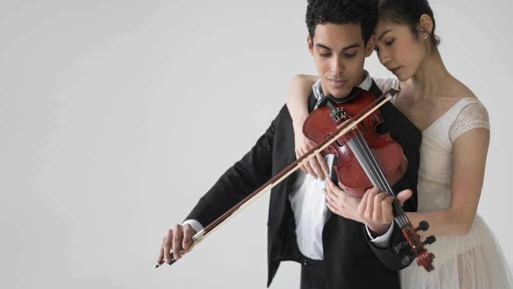 Ideas de entretenimiento para el día de tu boda 2 musician playing violin with ballerina copy space
